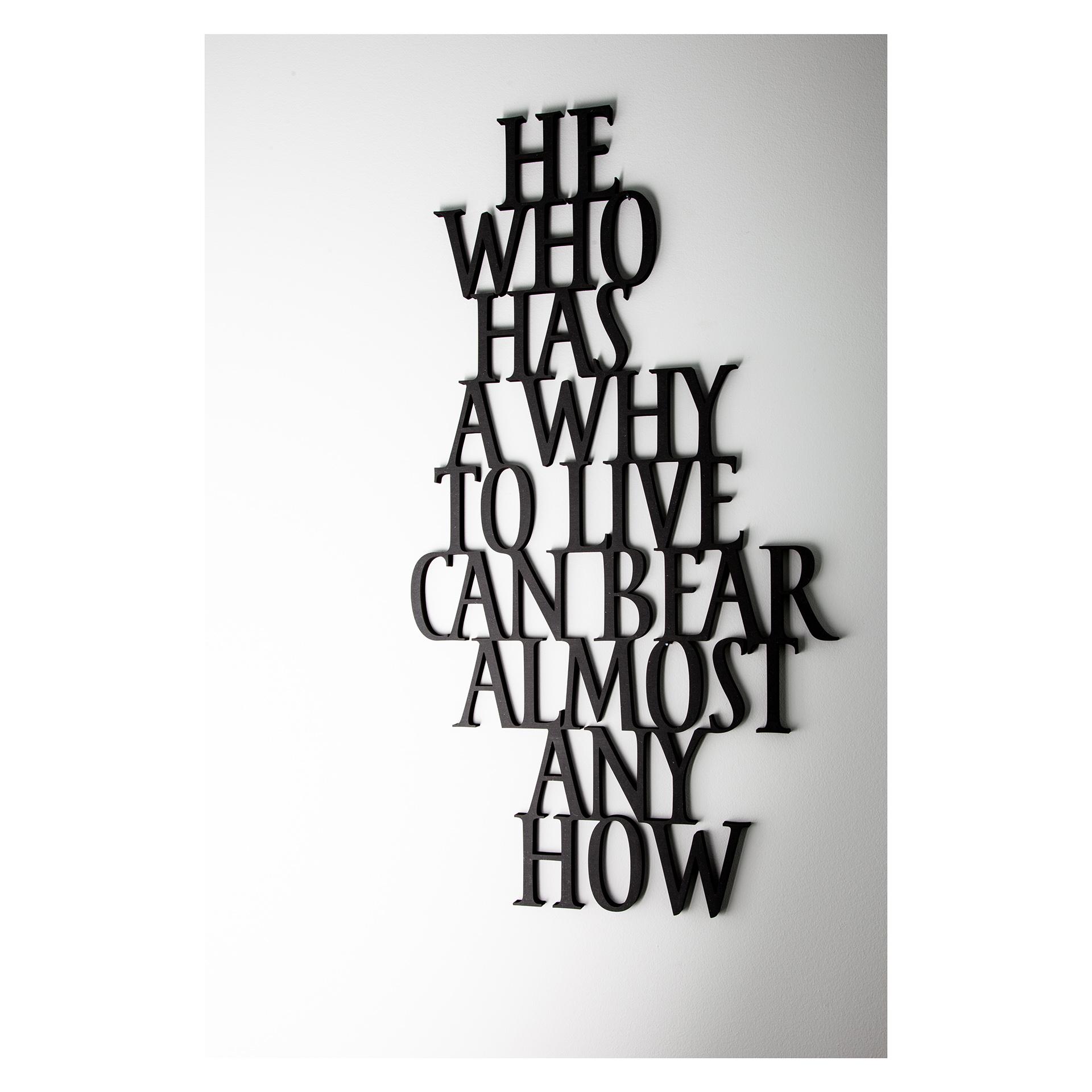 Muurtekst 'He who has a why to live can bear almost any how' - Zwart